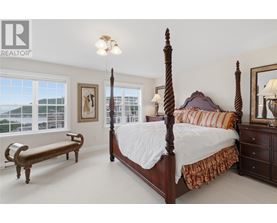 A bedroom with a large bed and a bench.