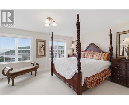 A bedroom with a large bed and a bench.