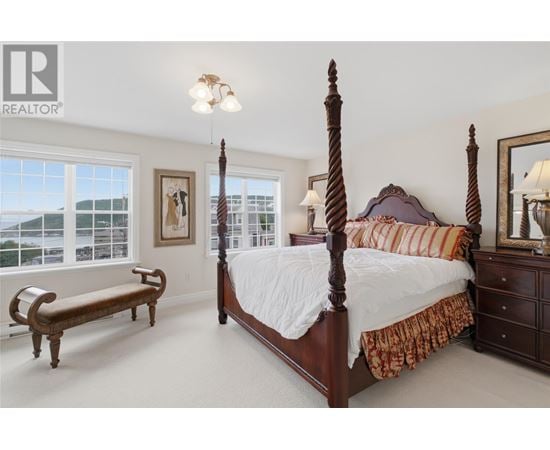A bedroom with a large bed and a bench.