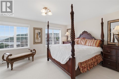 A bedroom with a large bed and a bench.