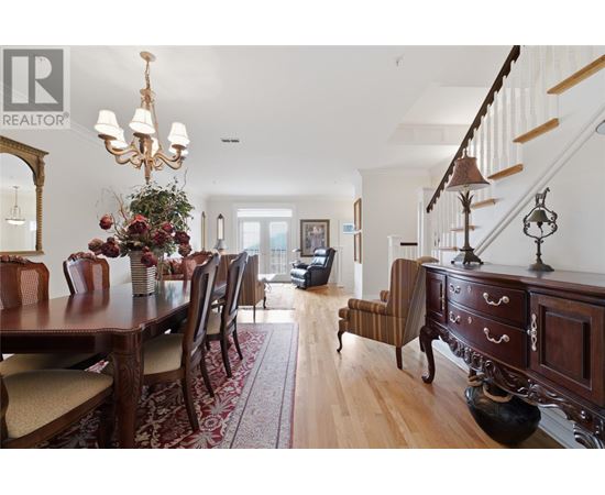 A dining room with a wooden table and chairs.