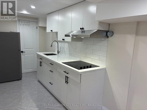 A white kitchen with a black stove top.