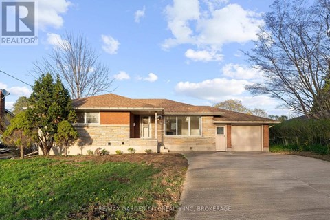 A house with a brown roof and a driveway in front.