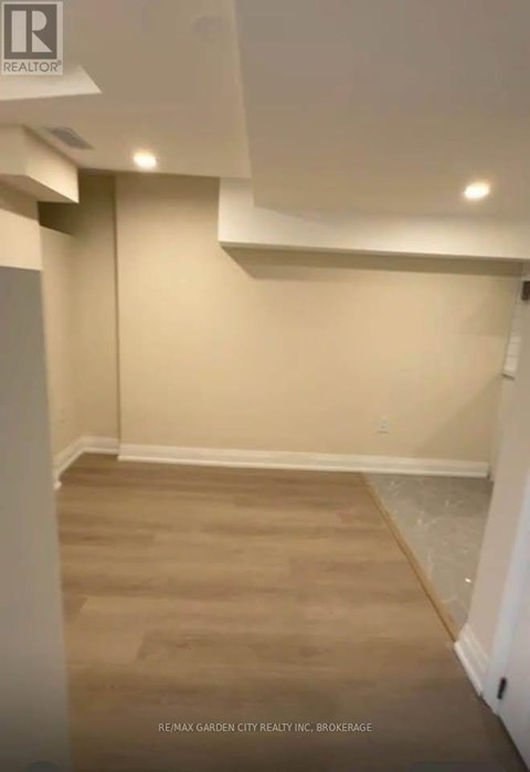 A room with beige walls and wooden flooring.