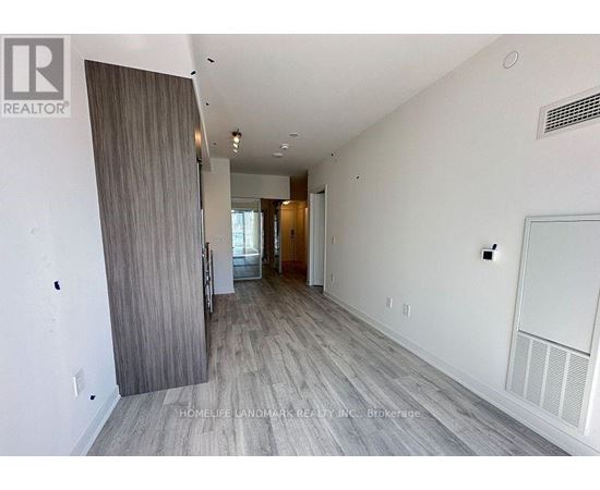 A spacious room with a sliding door leading to a balcony.