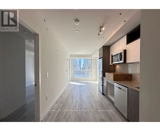 A spacious kitchen with a microwave and a box on the counter.