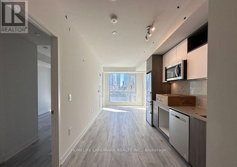 A spacious kitchen with a microwave and a box on the counter.