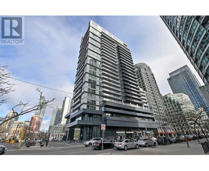 A tall building with a glass facade is the focal point of the image.