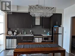 A modern kitchen with a wooden table in the middle.