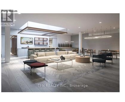 A modern party room with a large couch, a coffee table, and a long table with chairs.