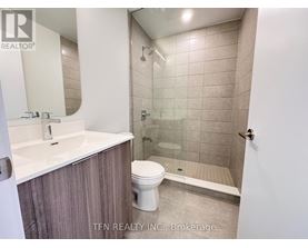 A bathroom with a toilet, sink, and shower.