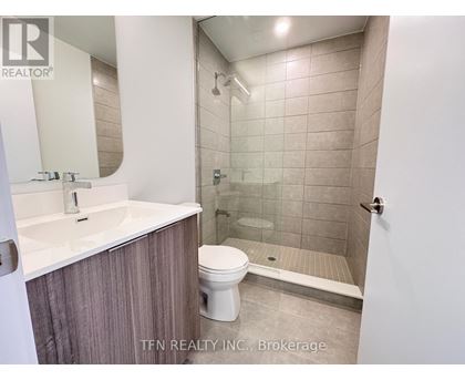 A bathroom with a toilet, sink, and shower.
