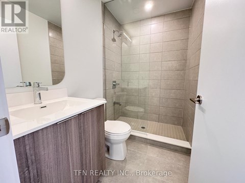 A bathroom with a toilet, sink, and shower.