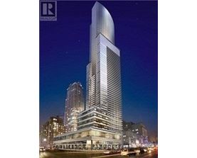 A tall, modern skyscraper stands prominently in the cityscape at night.