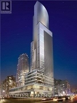 A tall, modern skyscraper stands prominently in the cityscape at night.