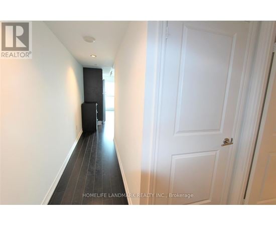 A hallway with a white door and a black door on the other side.