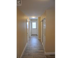 A hallway with stone tiles flooring and white doors.