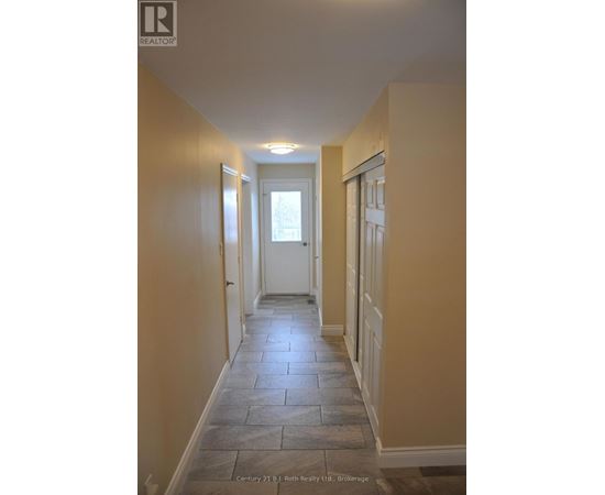 A hallway with stone tiles flooring and white doors.
