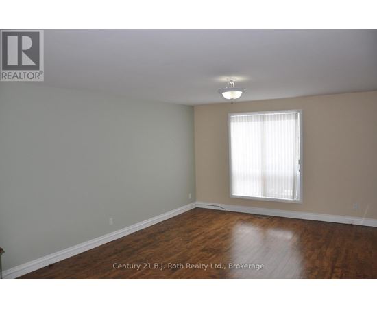 A room with a window and wooden floors.