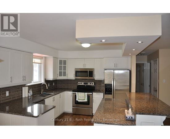 A kitchen with white cabinets and a black countertop.
