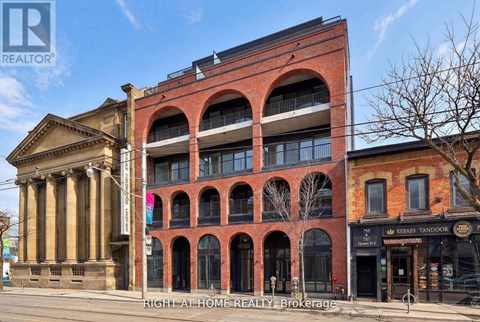 A building with a classical columned entrance and a red brick building with arched windows.