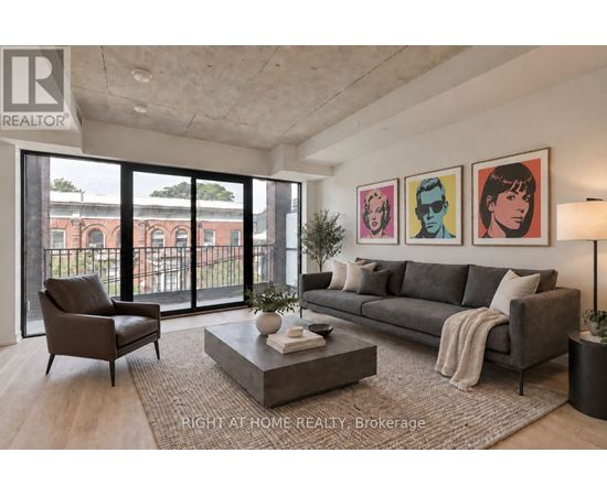 A living room with a grey couch, a coffee table, and a large window with a view of a building.
