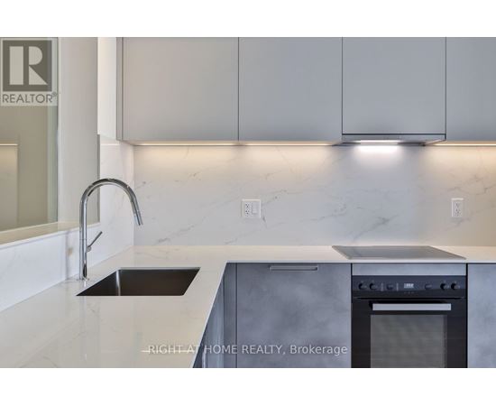 A modern kitchen with a sink and stove top oven.