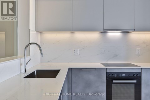 A modern kitchen with a sink and stove top oven.