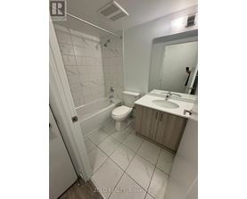 A bathroom with a toilet, sink, and mirror.