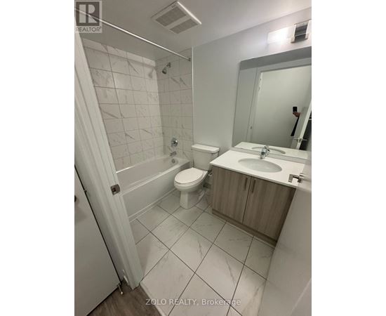 A bathroom with a toilet, sink, and mirror.