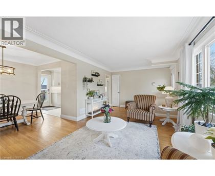 A living room with a white table and striped chairs.