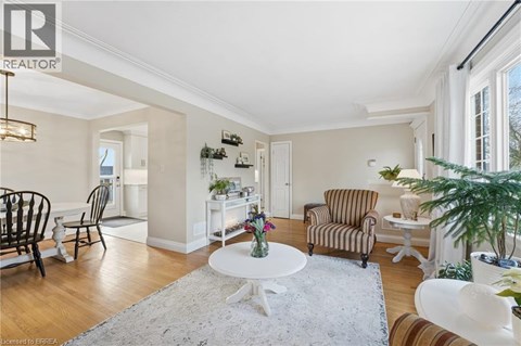 A living room with a white table and striped chairs.