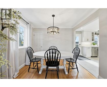 A dining room with a white table and four chairs.