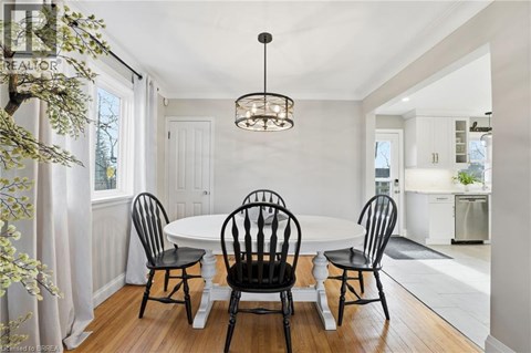 A dining room with a white table and four chairs.