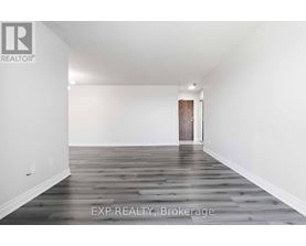 A room with wooden flooring and a door in the background.