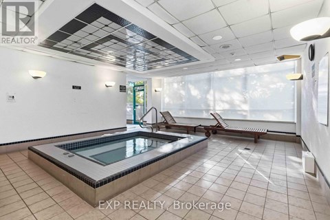 A pool in a room with tiled floors and ceilings.