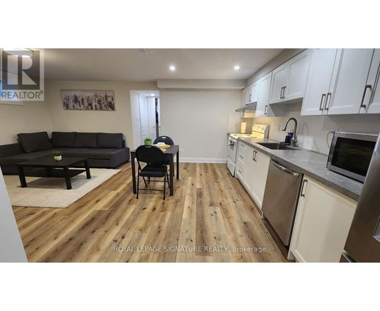 A kitchen and living room with wooden floors and white walls.
