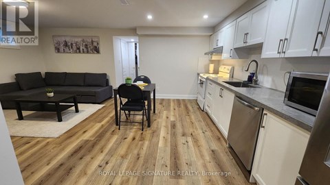 A kitchen and living room with wooden floors and white walls.