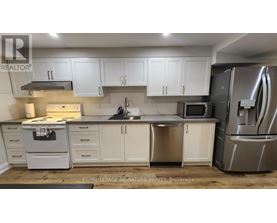 A kitchen with white cabinets and stainless steel appliances.