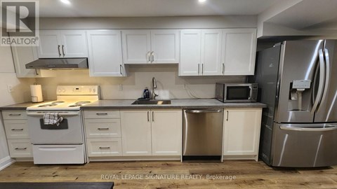 A kitchen with white cabinets and stainless steel appliances.