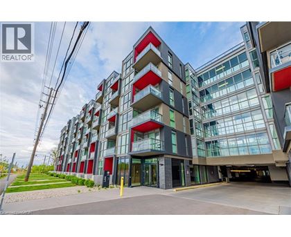 A modern multi-story building with a glass facade and red accents.