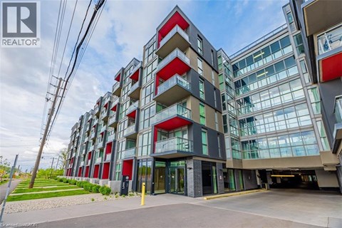 A modern multi-story building with a glass facade and red accents.