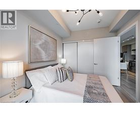 A bedroom with a large bed and a painting on the wall.