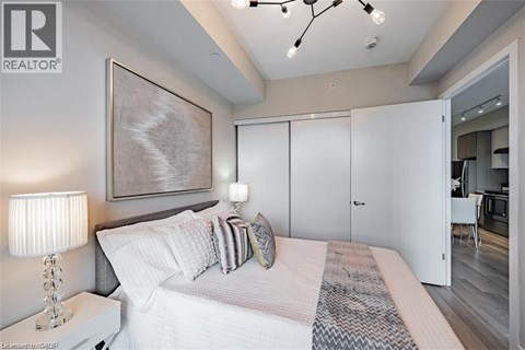 A bedroom with a large bed and a painting on the wall.