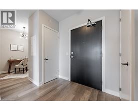 A black door is in the middle of a white wall.