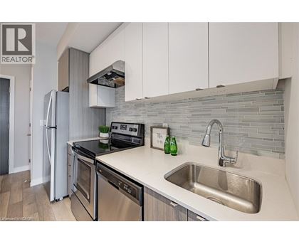 A modern kitchen with a stainless steel refrigerator and a sink.