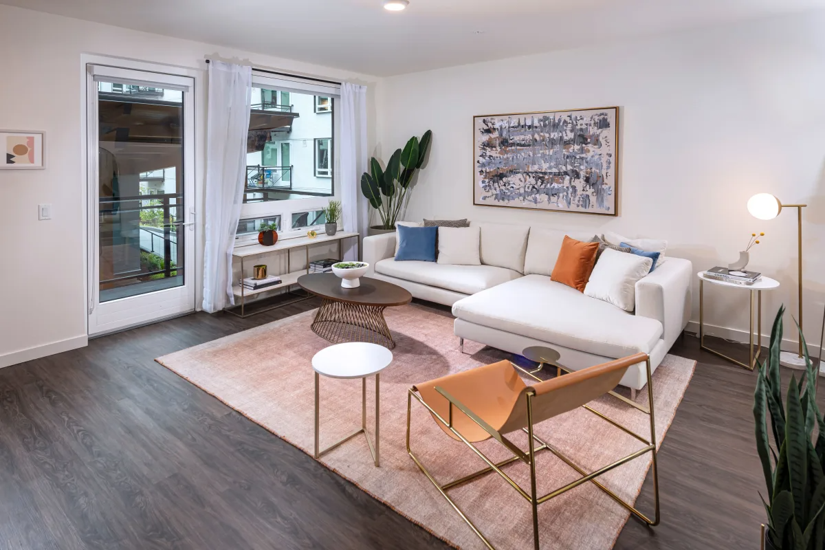 A living room with a white couch and a brown chair.
