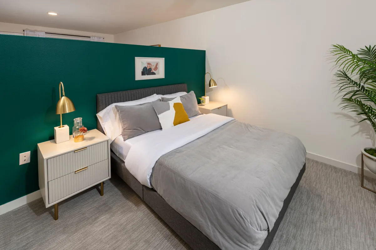 Bedroom with bed, side table, and decor at Nightingale Apartments in Redmond, WA.