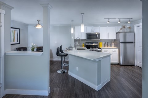 A kitchen with a white island and stainless steel appliances.