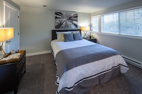 A bedroom with a large bed and a painting on the wall.